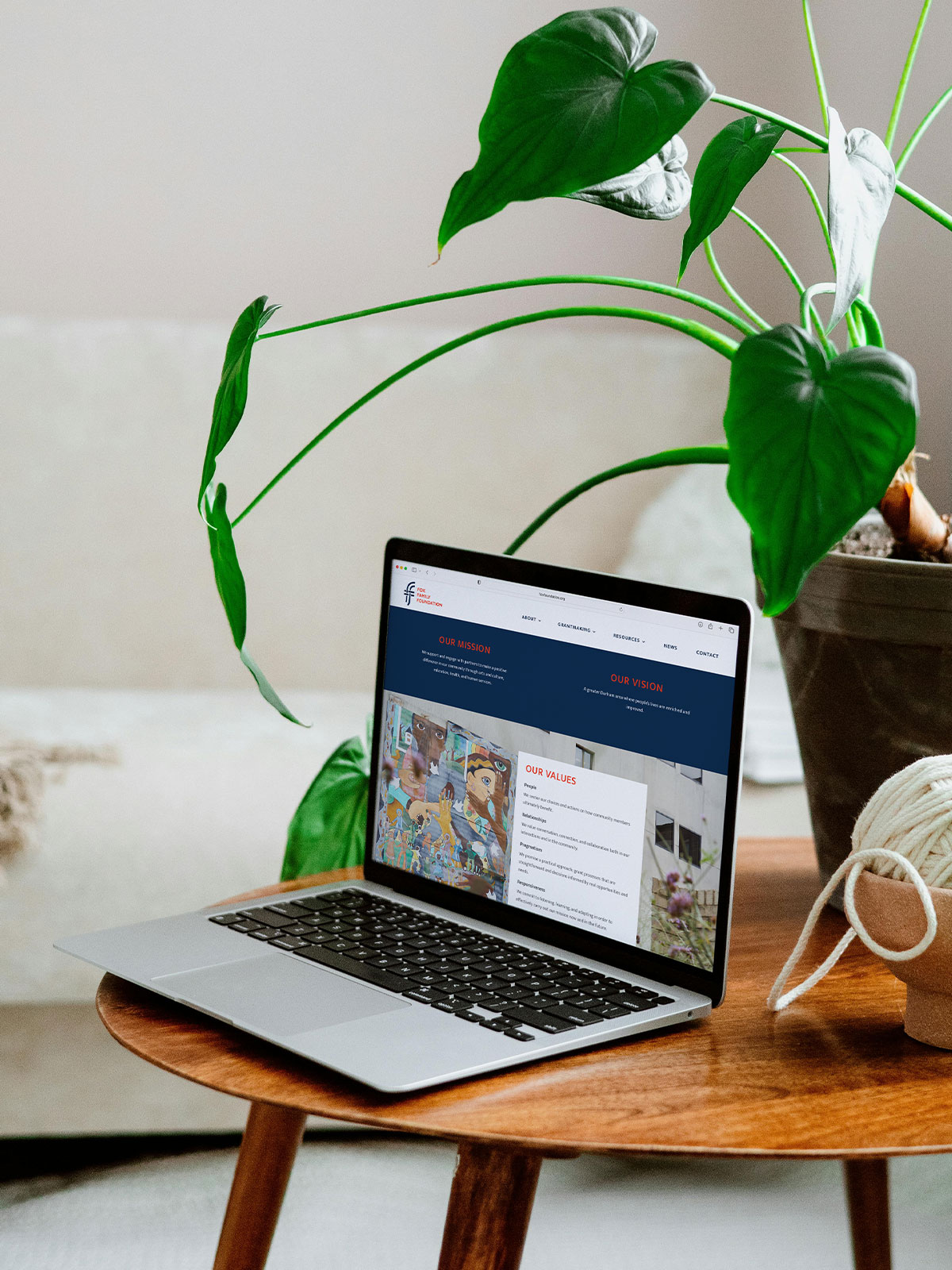 Fox Family Foundation website showing on laptop sitting on a coffee table with plants